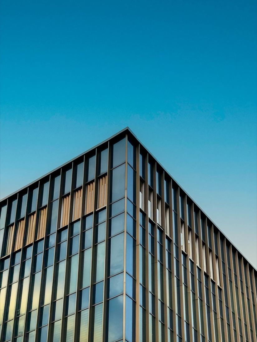 Corner of a modern building facade against a clear blue sky